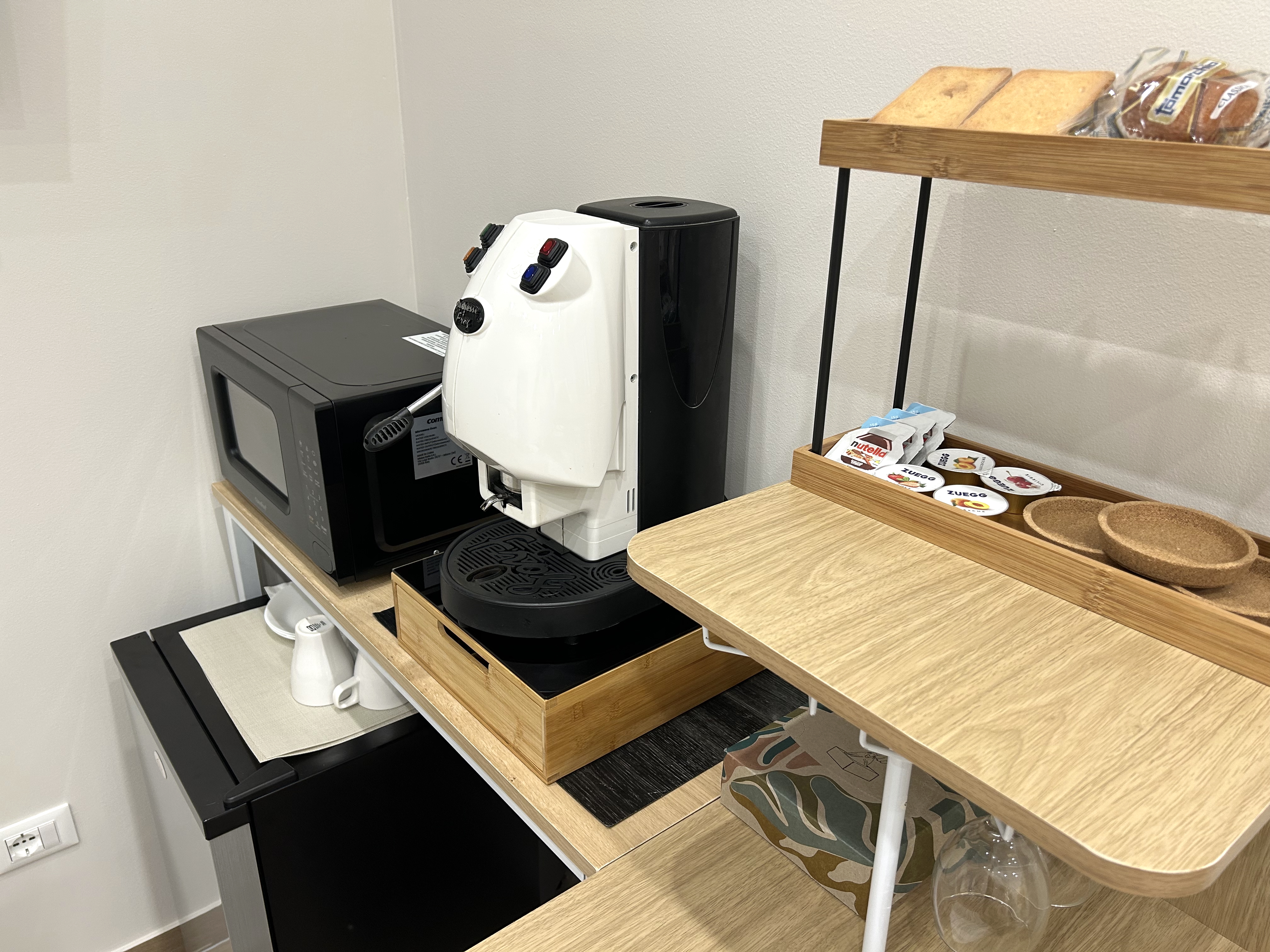 Angolo colazione con macchina del caffè, microonde e snack